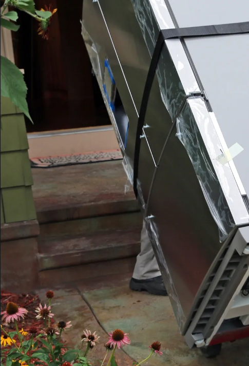 Refrigerator being delivered to a home entrance