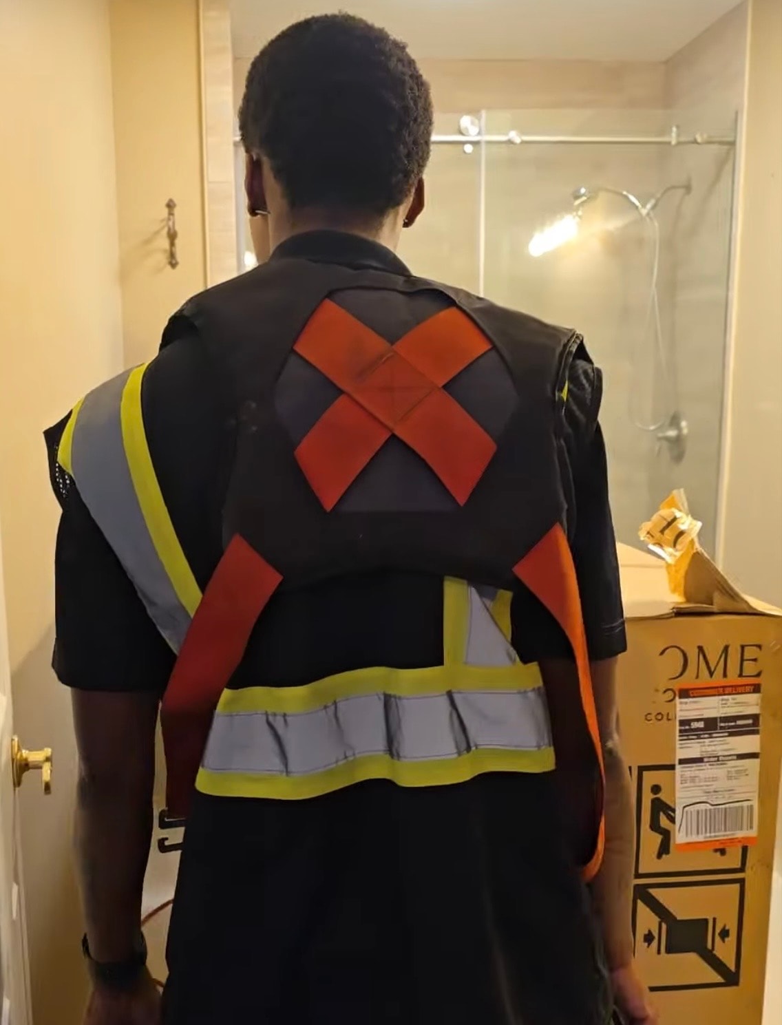 TTC crew member in safety vest positioning a stainless steel refrigerator in a kitchen
