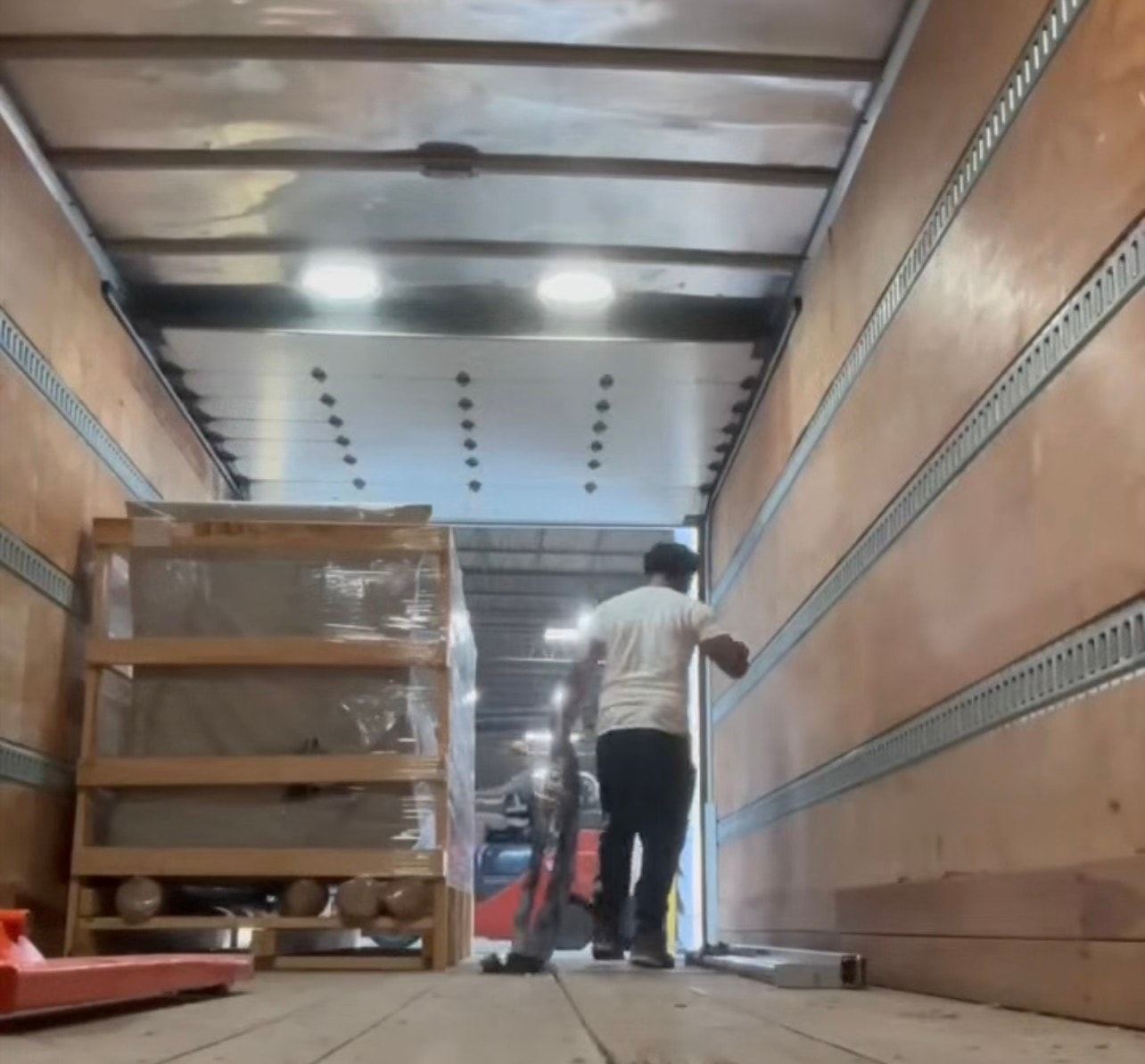 TTC crew member guiding a large boxed item through a bathroom doorway